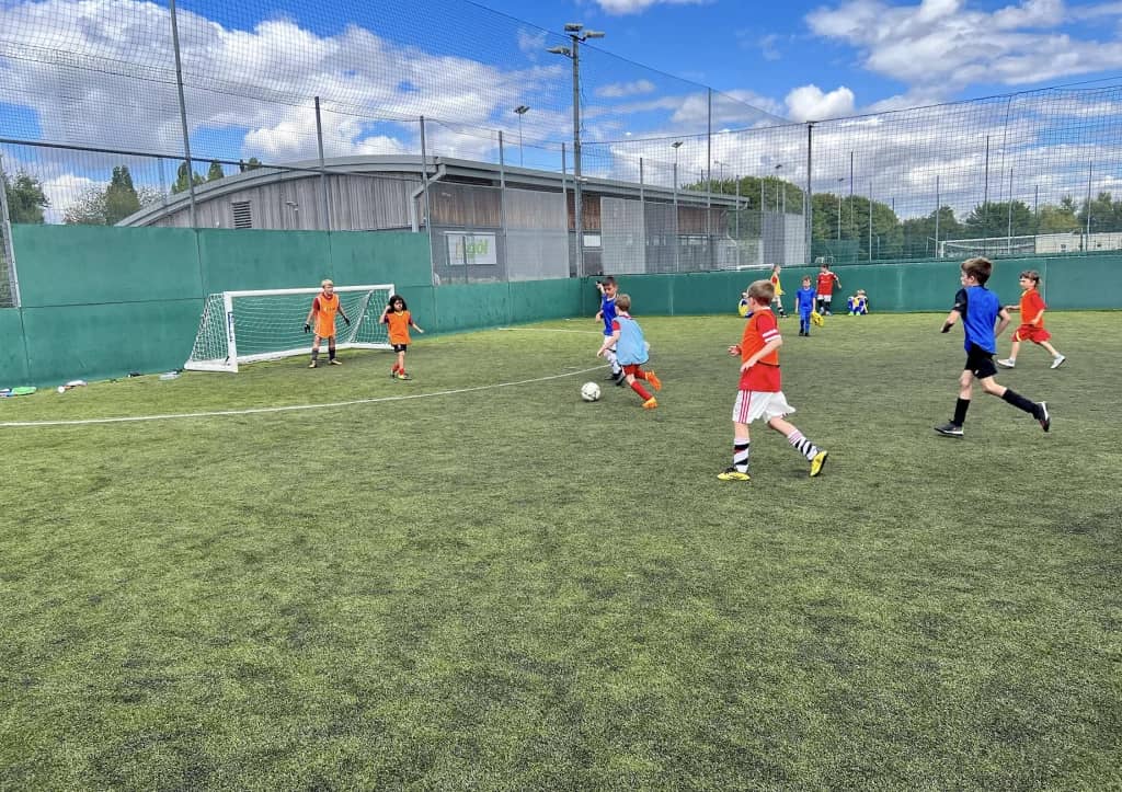 Children playing football on an outdoor pitch