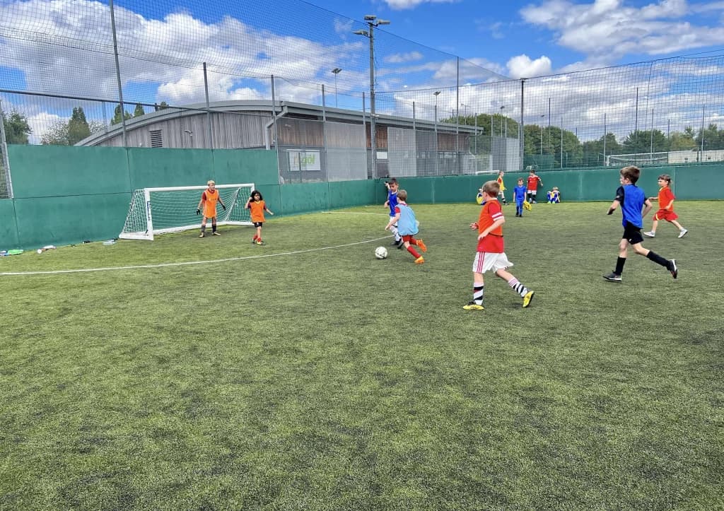 Children playing football on an outdoor pitch