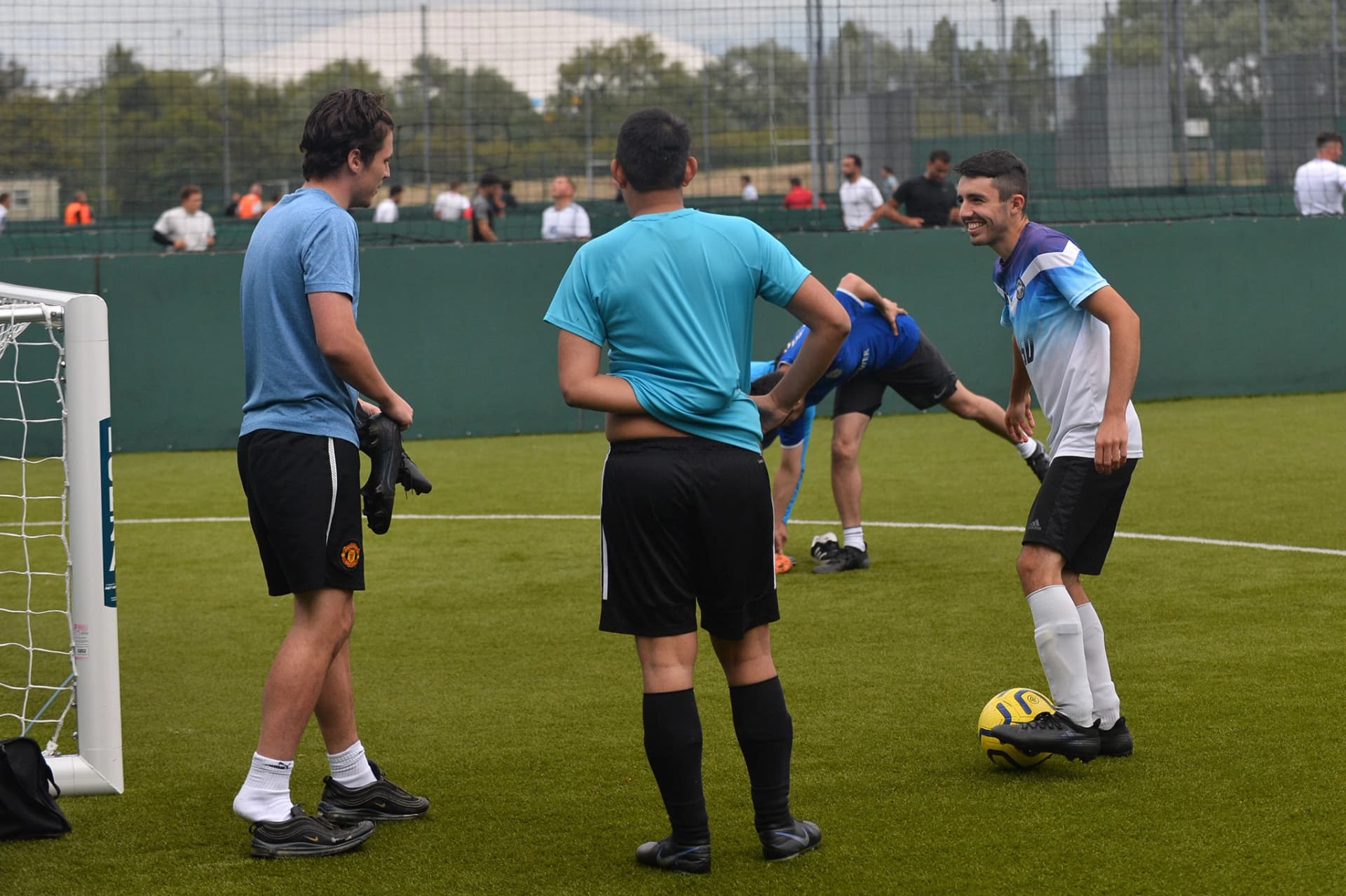 Players competing in a 5-a-side match on an indoor pitch