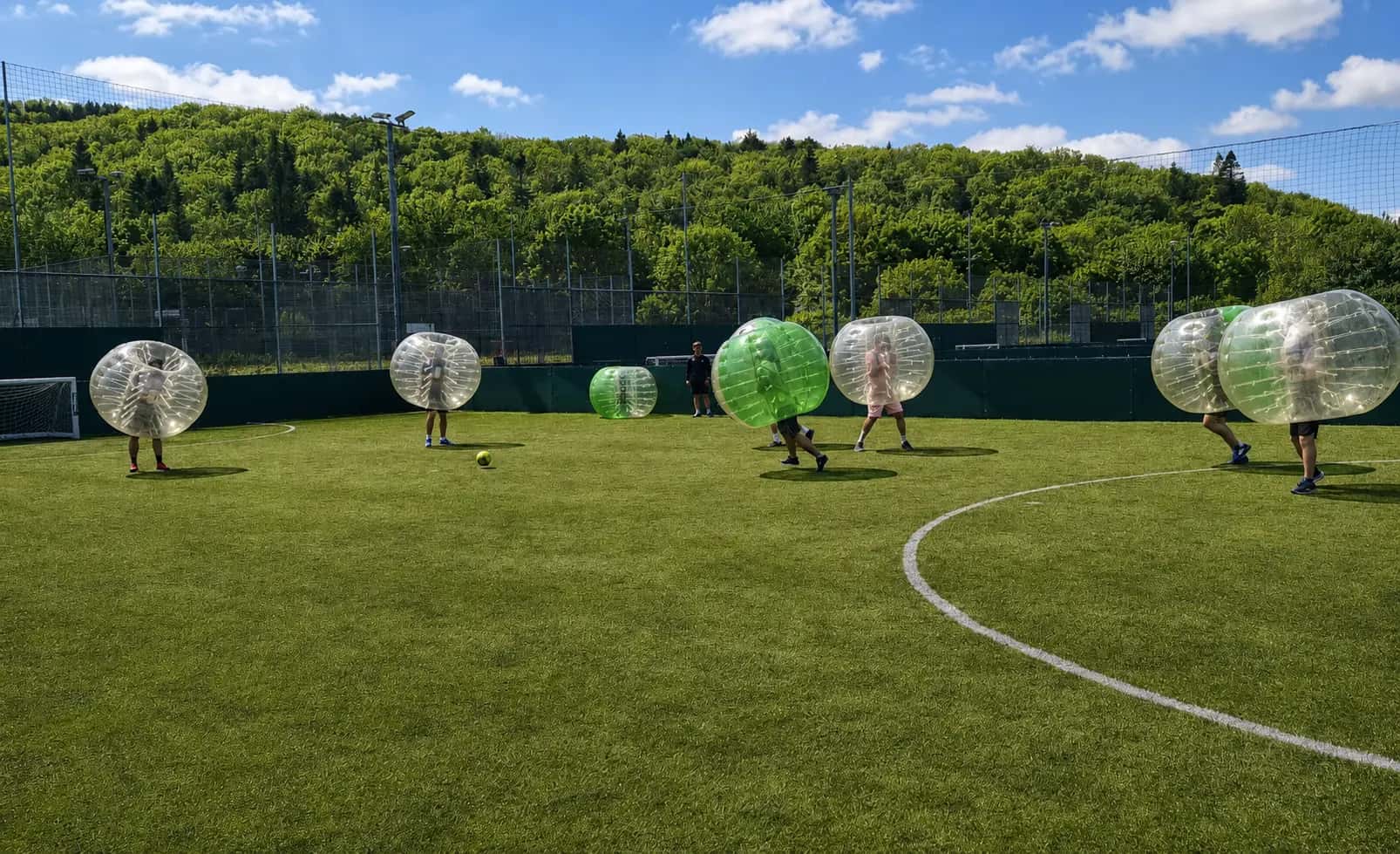 Players in inflatable bubbles playing football on a pitch at Gôl Cardiff