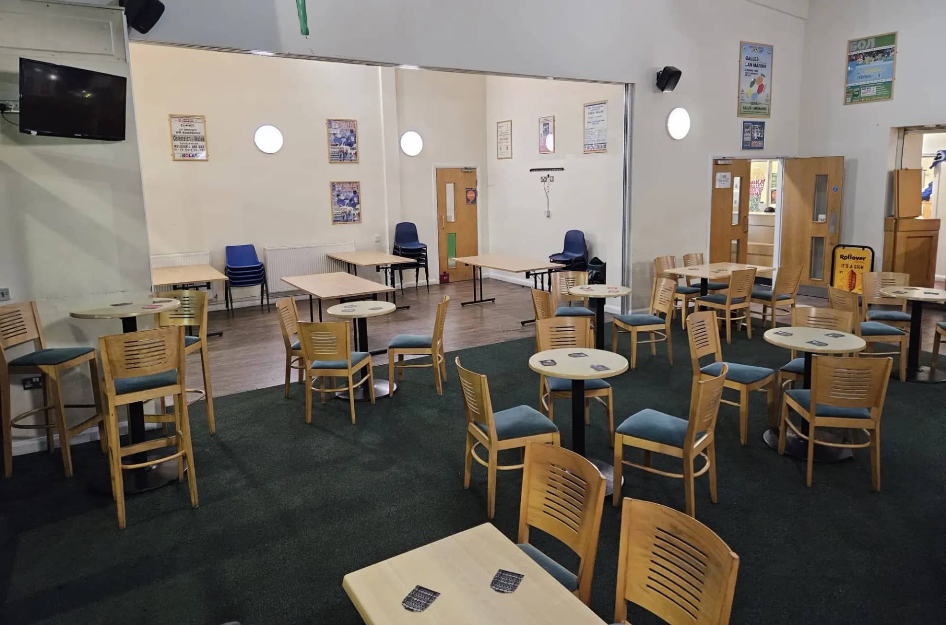 Lounge seating beside the wide opening to the adjoining function area and its rectangular tables