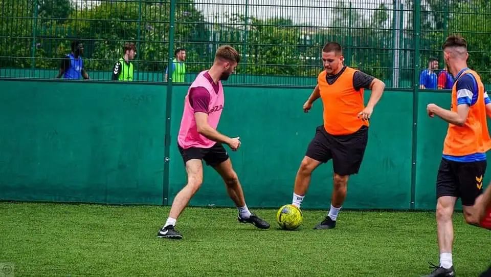 A player closing down an opponent in a 5-a-side match